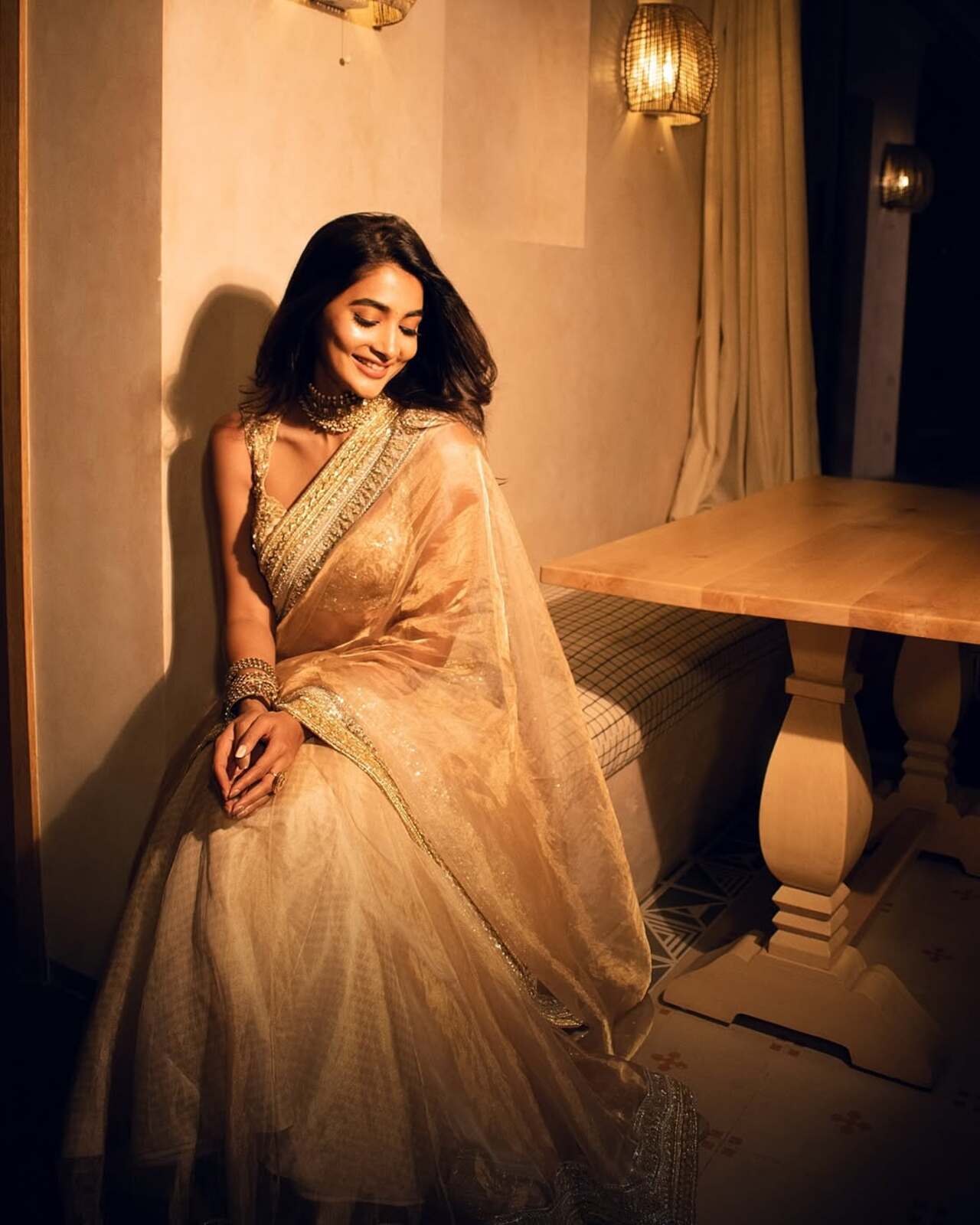 Pooja Hegde served unstoppable glamour in a golden tissue saree featuring a heavy border. She paired the dazzling drape with a heavily worked-up blouse that complemented the tissue fabric. Pooja levelled up the accessory department by donning heavy jewellery pieces, including golden kadas, a choker and a ring